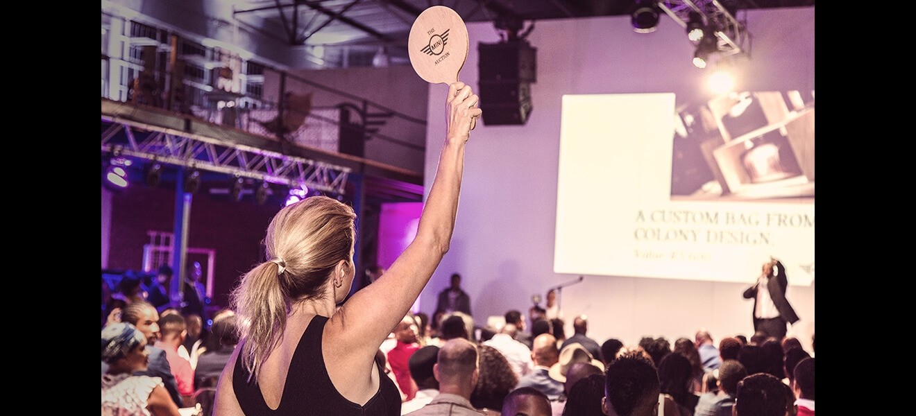 Enthusiastic bidders compete for a full-grain bovine leather bag with 100% cotton twill lining and Italian brass hardware from Colony Design.